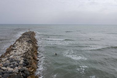 Dalgalı denizlerde sörfçü