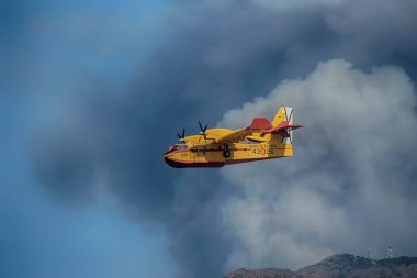 Yangının üzerinde uçan bir deniz uçağı