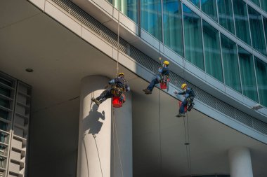 Milan İtalya 'nın 29 Mart 2021: Yukarıdan gelen askılarla kendilerini alçaltan yetenekli cam temizleyicileri