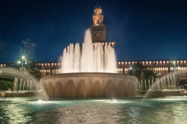 Milan 'ın tarihi sembolü Sforza Kalesi' nin gece çekilmiş fotoğrafı. Merkezi kırmızı tuğla kule, Rönesans mimari detaylarıyla sahneye hakim..