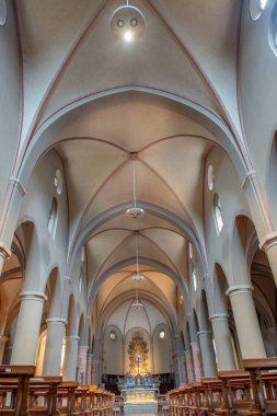 Cremona 'daki San Luca Kilisesi' nin içinde simetrik merkez nav, heybetli sütunlar, yüksek tavan ve arka planda süslenmiş sunak var.