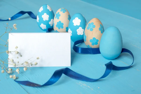 Painted Easter eggs on blue wooden background — Stock Photo, Image