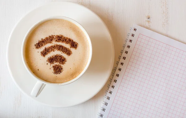 Símbolo WiFi hecho de canela como decoración de café en taza de capuchino. fondo de madera blanco — Foto de Stock