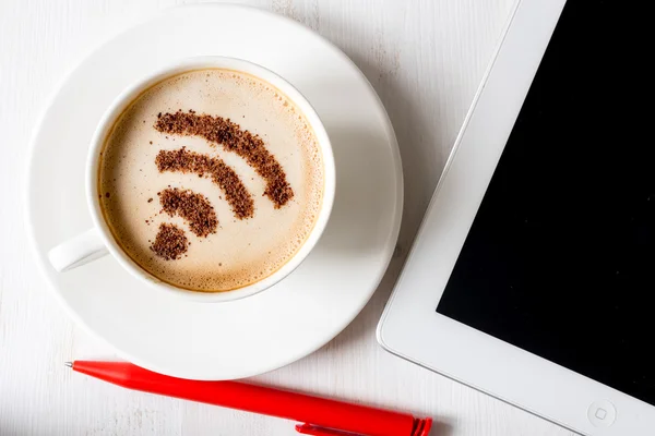 WiFi symbol gjord av kanel som kaffe dekoration i kopp cappuccino. Laptop på vit trä bakgrund — Stockfoto