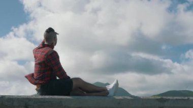 Adam telefonda dağlara tepeden bakarak konuşuyor. Güzel bir otelden mutlu bir adamı arıyor. Güzel manzarası olan genç bir adam.