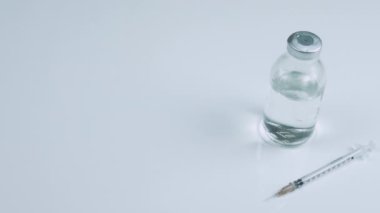 Kavanozda ilaç olan bir şırınga, virüs için tıbbi bir ilaç. Beyaz arka planda ilaç olan ilaç kavanozu.