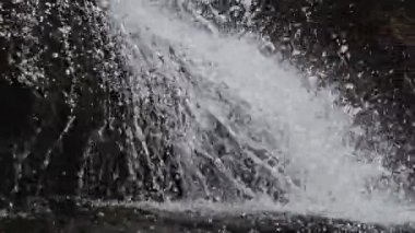 Şelale, dağ nehri taşlardan akıyor, su damlaları, kayalara yakın çekim.