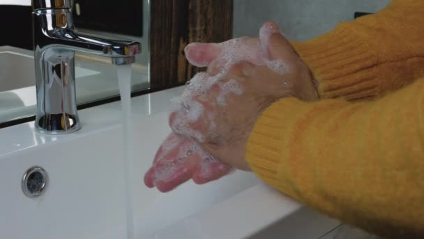 若い男が水道の下で石鹸と水で手を洗う — ストック動画