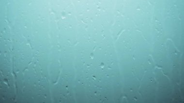Yağmur damlaları camdan süzülür, soyut arka plan, yağmur arkaplanı. Pencerenin dışında şimşek çakan bir fırtına