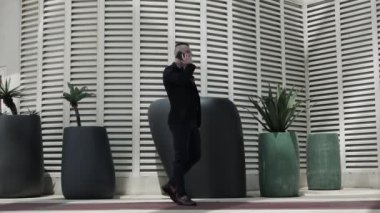 Telefonda kötü haber, üzgün bir iş adamı, güzel saçlı şık bir adam, iş merkezinde telefonla konuşan genç bir adam.