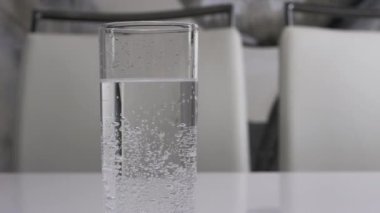 Beyaz arka planda bardaktaki su, köpüklü maden suyu, yakın plan, içme suyu..