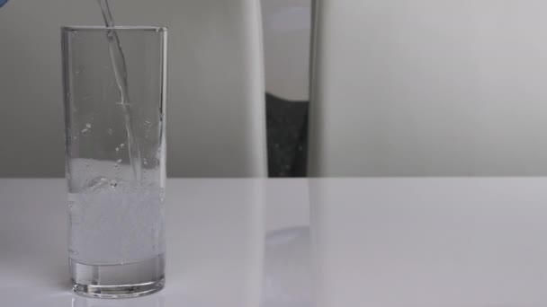 Ρίξτε Μεταλλικό Νερό Ένα Ποτήρι Ένα Χιόνι Λευκό Φόντο Νερό — Αρχείο Βίντεο
