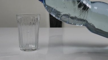 Plastik şişeden maden suyunu mutfaktaki cam şişeye dök. Maden suyu akışı
