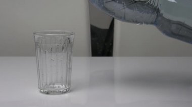 Plastik bir şişeden cam bardağa su dök, kristal berrak su, bardakta su iç.