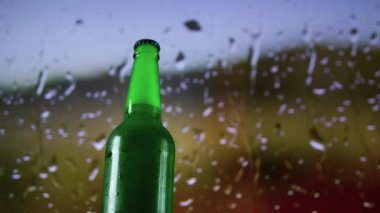 Efektli bira şişesi, yakın çekim, yağmur damlalarının arka planında şişede hafif bira. Bira ekran koruyucu