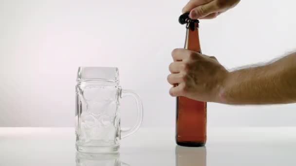 Een Man Opent Een Fles Bier Met Een Opener Giet — Stockvideo