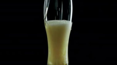 Siyah arka planda bir bardakta hafif bira. Yakın plan.