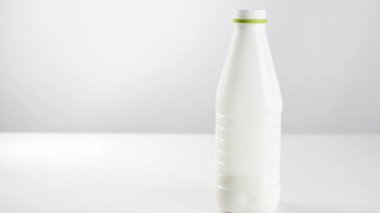Beyaz arka planda plastik bir şişede süt ürünü, cam bir şişede yoğurt. Kefir.