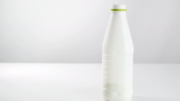 白い背景にプラスチックボトルの乳製品 ガラス製のビーカーでヨーグルト ケフィア — ストック動画