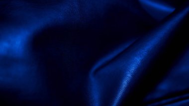 Koyu arkaplan, mavi tonlarda kıvrımlar, yazı için boşluk, buruşuk deri dokusu. Matte bitiş