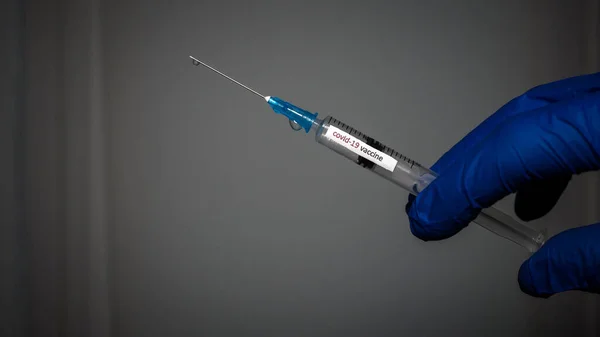 医師の手による注射器 医療従事者によるワクチンによる医療用注射器で撮影されました 薬は注射器に入っています 2020ウクライナ — ストック写真