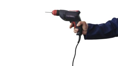 Bir inşaatçının elindeki elektrikli matkap beyaz arka planda izole edilir. İnşaat tulumlu bir adam elinde matkap tutar..