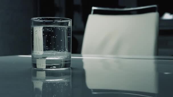 一杯清澈的矿泉水 桌上的饮用水 矿泉水的气泡 — 图库视频影像