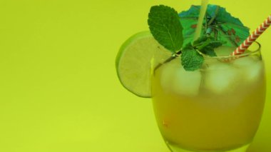 Alkolik içki yakın plan, bardağa portakal suyu doldurmak, sarı arka planda yaz içkisi.