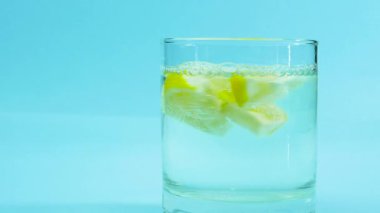 Limonlu taze içecek, meyveli limonata kokteyli. Mavi arka planda limonlu maden suyu içmek.