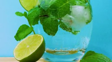 Güzel baloncuklu mojito kokteyli, yakın çekim, pipetli alkollü meyve suyu. Bardakta alkollü nane şekeri. Taze bir içecekle limon dilimleri.