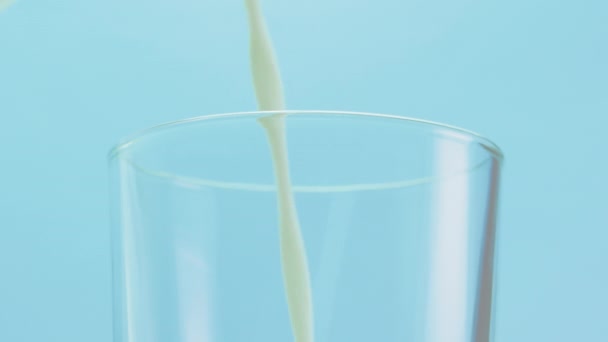 Häll Mjölk Glasstudio Skjuten Blå Bakgrund Närbild Mjölk Häller Ett — Stockvideo