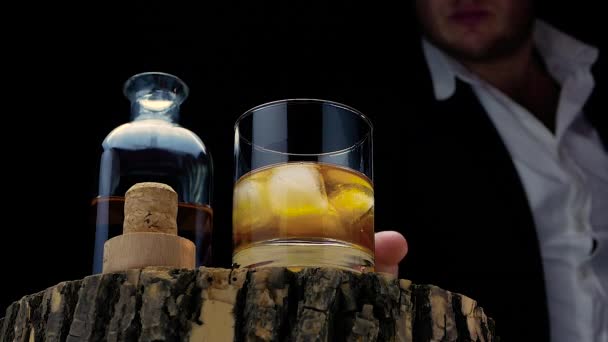 Mężczyzna Szklanką Whisky Rękach Whiskey Lodem Czarnym Tle Drewnianej Desce — Wideo stockowe