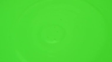 A drop of acrylic paint gets into the paint. Green colorful blob background. Aqua colorful yellow abstract. Liquid paints for topical use