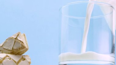 Mavi arka planda sütlü börekler. Şişeden bardağa taze süt dök..