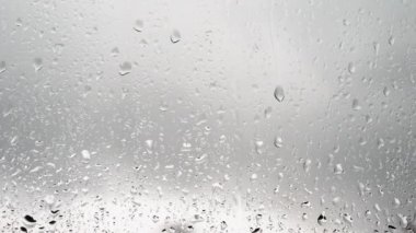  Damlalar camdan aşağı akıyor. Yağmur zemini. Pencerenin dışında yağmur var. Yağmur damlalarının güzel arkaplanı