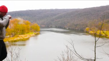 Adam tepedeki nehir kıyısında boks yapıyor. Bir erkek spor için doğaya gider. Sonbaharda ormanda boksör eğitimi.