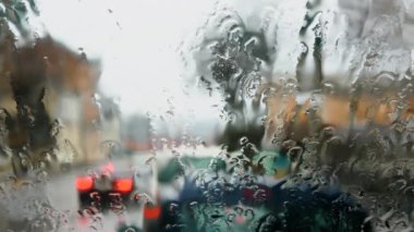 Bulanık yağmurda sirenleri olan itfaiye aracı. Camdaki yağmur damlaları, yağmur arkaplanı. Pencerenin dışında fırtına var. Otoyol