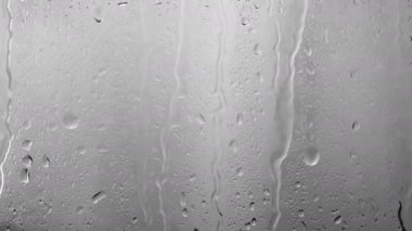 Güzel, yağmurlu bir zemin, bardaktan aşağı yağmur damlaları akıyor, pencerenin dışında sağanak var, pencereleri yıkayan bir fırtına var. Bardağa biraz su dök.