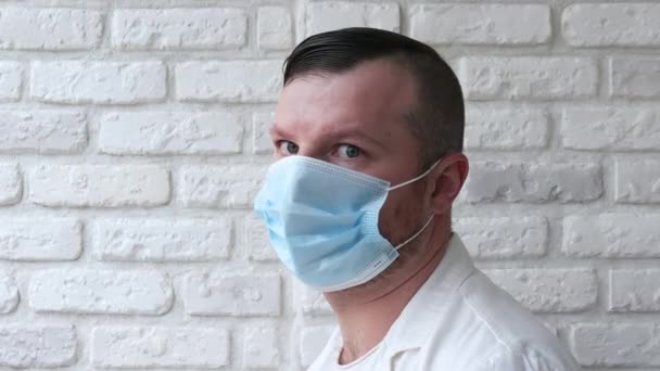 Yüzünde Tıbbi Maske Olan Yakışıklı Bir Adamın Portresi Beyaz Tuğla — Stok video