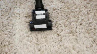 Yünlü halıları yakın çekimde temizliyorum. Kabarık halıları elektrikli süpürgeyle temizliyorum. Otel odalarının temizliği