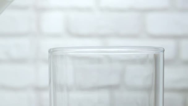 在白底的杯子里倒入鲜牛奶 在特写镜头下喝牛奶 在杯子里倒入牛奶 — 图库视频影像