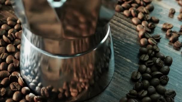 木製ボード上の散乱コーヒー豆との密接なアルミ間欠泉コーヒーメーカー コーヒーの背景 — ストック動画