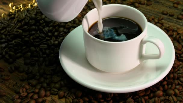 Dodaj Mleko Śmietankowe Czarnej Kawy Drewnianej Desce Ziarna Kawy Kubkiem — Wideo stockowe