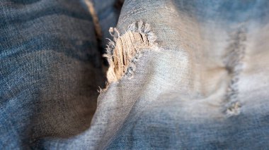 Denim background. Blue ripped jeans close-up. Denim
