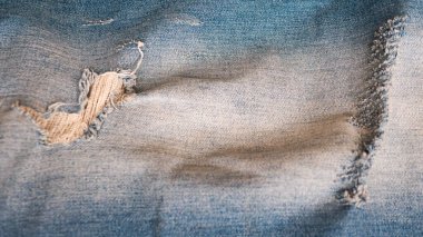 Washed denim. Blue jeans close-up. Leaky stylish jeans