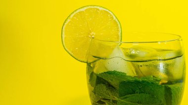  Cool summer fresh. Drink with mint in a glass, a slice of lime in a glass with a drink. Alcoholic drink in a glass with mint. Mojito.