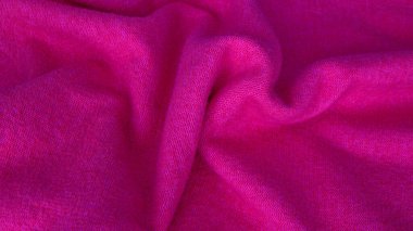 Background with wavy lines made of natural silk fabric of different colors. Pink fabric background. Background from silk fabric. Copy space.