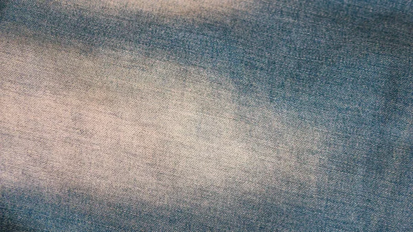 Denim background. Blue jeans with white spots close-up. Denim