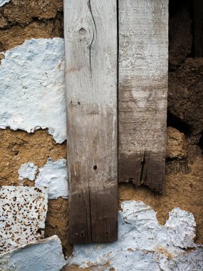 Tahtalarla çamurdan yapılmış antik bir duvar. Eski bir duvarın dikey resmi. Boya ve kalaslar çivilenmiş..