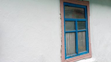 Balçıktan yapılmış beyaz bir evin klasik pencereleri, tahta pencereli Cadılar Bayramı arka planı. Eski ahşap pencere.